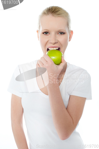 Image of Healthy young girl eating nutritious green apple