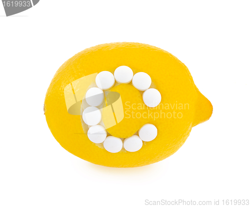 Image of Lemon with vitamin c pills over white background 