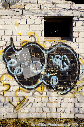 Image of Graffiti paint on abandoned building brick wall 