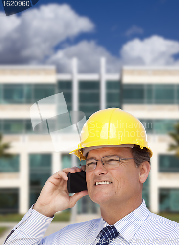 Image of Contractor in Hardhat Talks on Phone In Front of Building