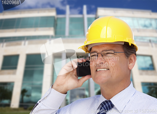 Image of Contractor in Hardhat Talks on Phone In Front of Building