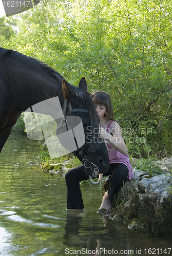 Image of child and horse in river