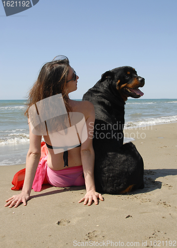 Image of woman on the beach with her rottweiler