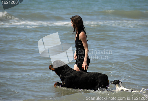 Image of woman and dogs on the sea