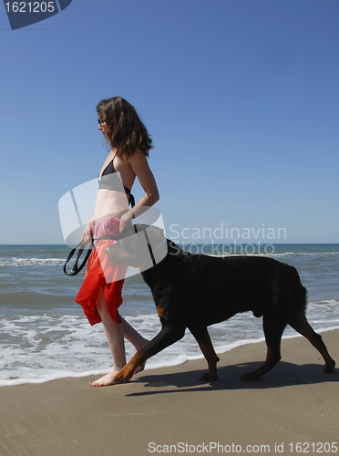 Image of woman and rottweiler on the beach