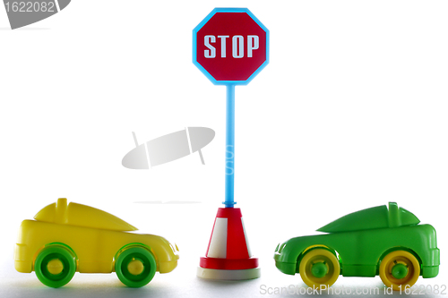 Image of A couple cars behind stop road sign