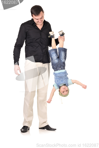 Image of Man holds little boy upside down