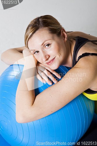 Image of Pregnant woman relaxing against fitness ball