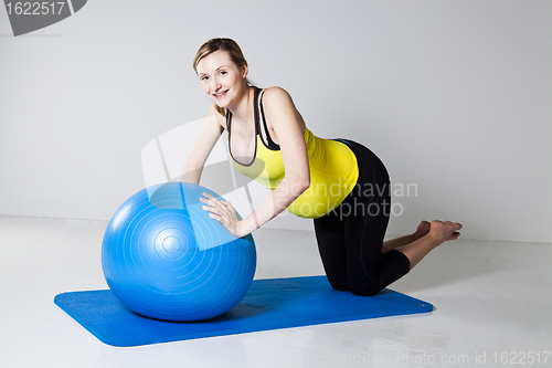 Image of Pregnant woman doing push-up exercise