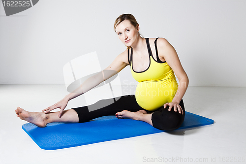 Image of Pregnant woman performing leg stretch