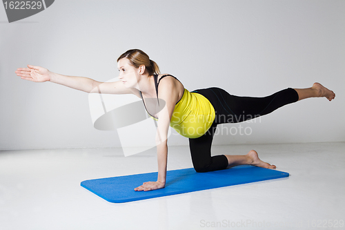 Image of Pregnant woman exercising on mat