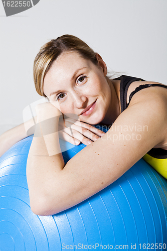 Image of Pregnant woman relaxing against fitness ball