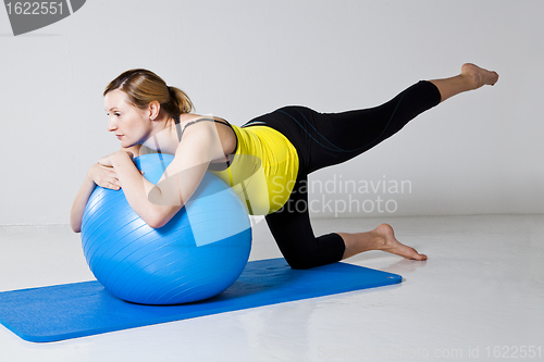 Image of Pregnant woman exercising with fitness ball