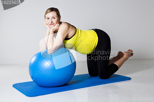 Image of Pregnant woman exercising with fitness ball