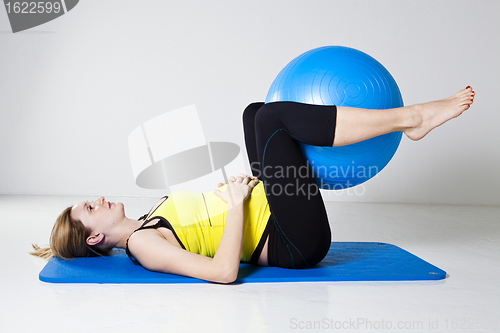 Image of Pregnant woman exercising with fitness ball