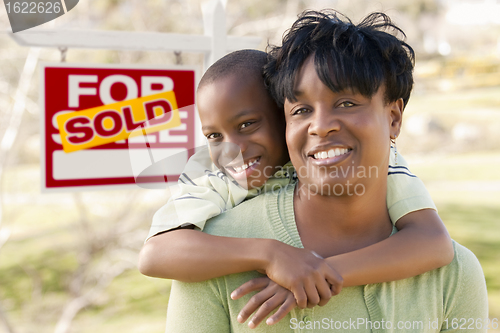 Image of Mother and Child In Front of Sold Real Estate Sign