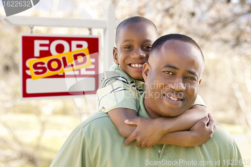 Image of Father and Son In Front of Sold Real Estate Sign