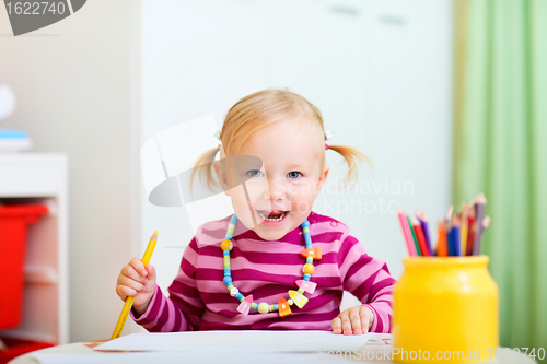 Image of Toddler girl drawing with pencils