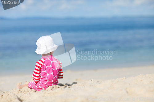 Image of Back view of toddler girl on beach