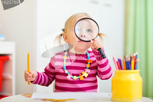 Image of Toddler girl looking through magnifier