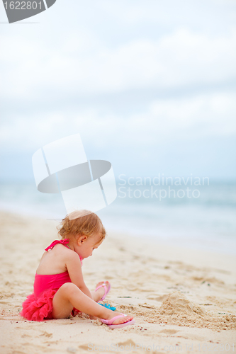 Image of Toddler girl playing with toys at beach
