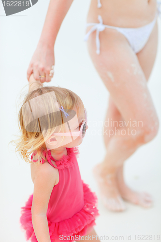 Image of Mother and daughter walking at beach