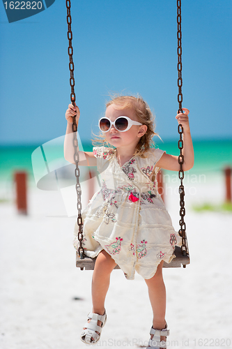 Image of Little girl swinging