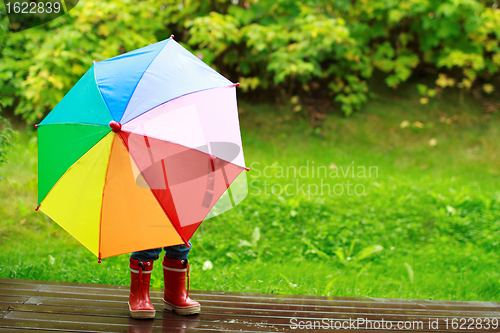 Image of Little girl hiding behind umbrella