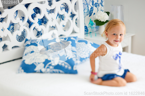 Image of Adorable smiling toddler girl in bedroom