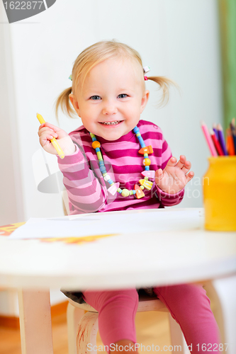 Image of Toddler girl drawing with pencils