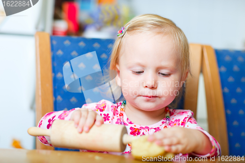 Image of Toddler girl helping at kitchen