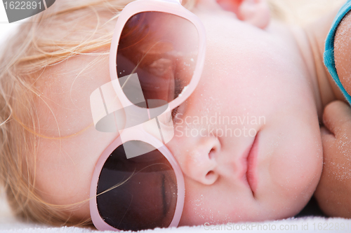 Image of Little girl sleeping at beach