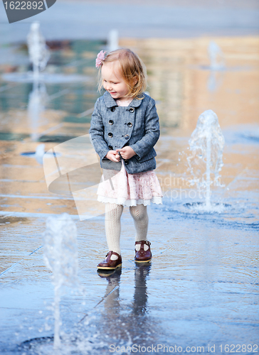 Image of Little girl playing in street fountain
