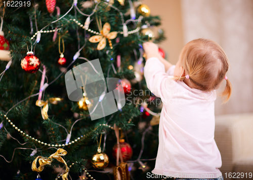Image of Little girl decorating Christmas tree
