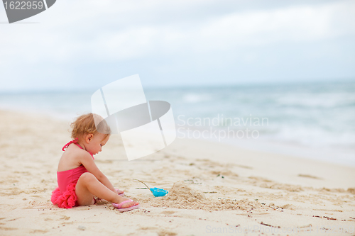 Image of Toddler girl playing with sand