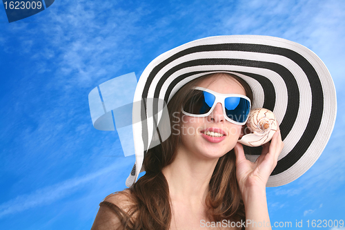 Image of girl listens seashell