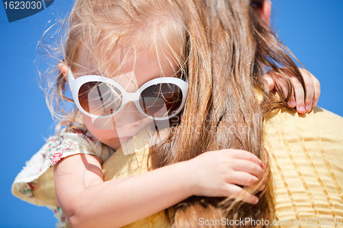 Image of Close up of little girl hugging mom