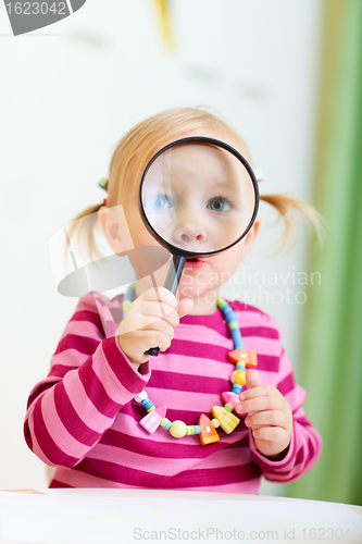 Image of Toddler girl looking through magnifier