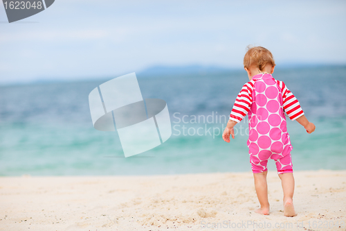 Image of Toddler girl sitting on white sand beach