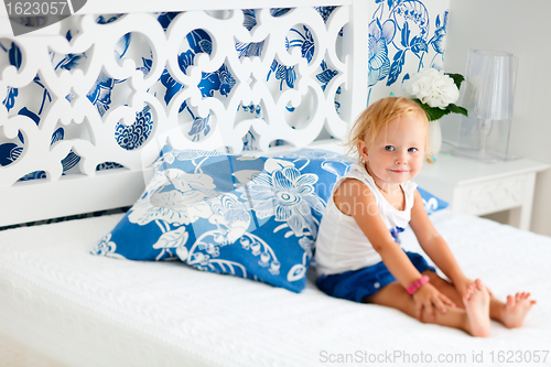 Image of Toddler girl sitting on bed