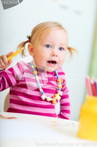 Image of Toddler girl drawing with pencils