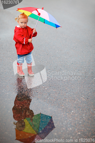 Image of Toddler girl with colorful umbrella on rainy day