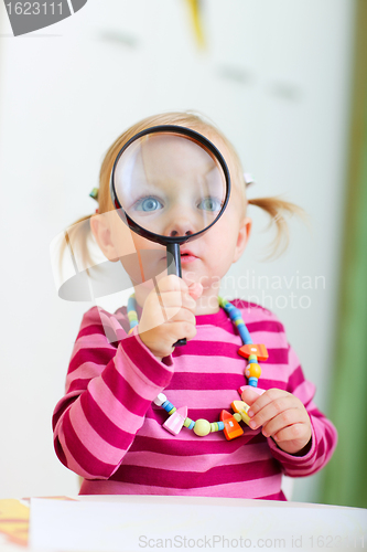 Image of Toddler girl playing with magnifier