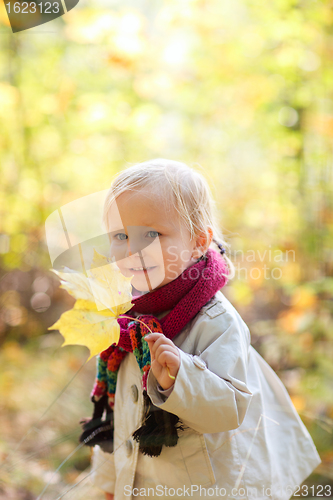 Image of Toddler girl holding yellow leaf