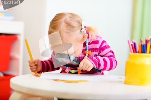 Image of Toddler girl looking through magnifier