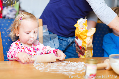 Image of Toddler girl helping at kitchen