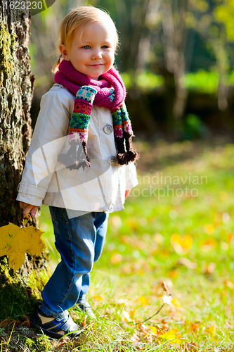 Image of Toddler girl standing near tree