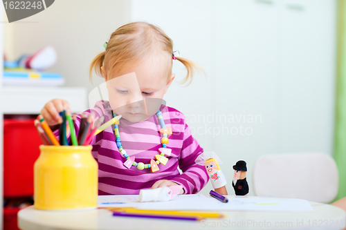 Image of Toddler girl coloring with pencils
