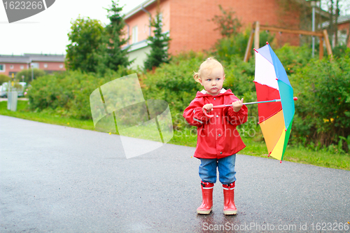 Image of Toddler girl with umbrella outside on rainy day