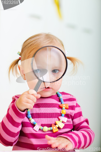 Image of Toddler girl looking through magnifier